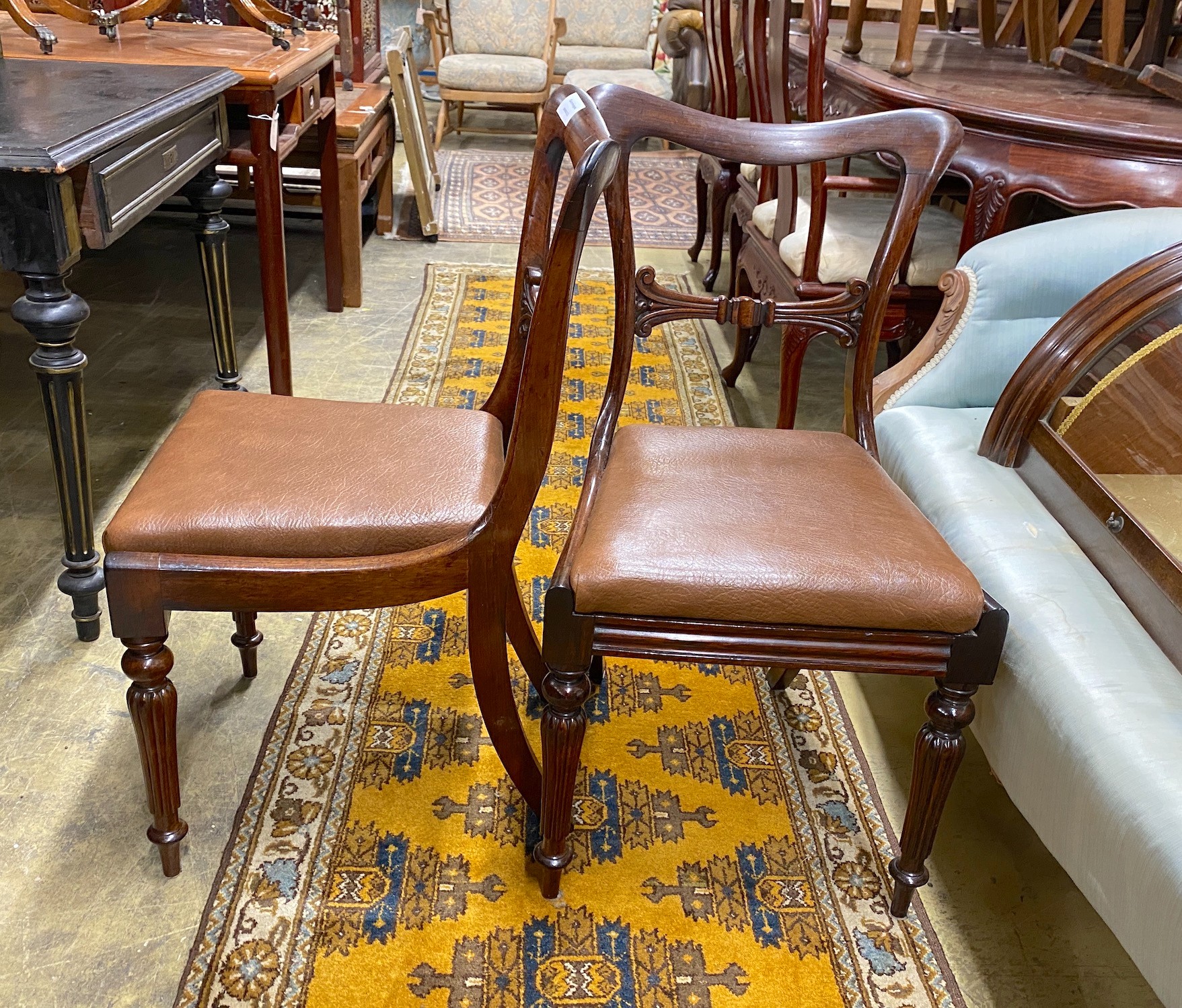 A set of four early Victorian rosewood dining chairs with drop in faux leather seats